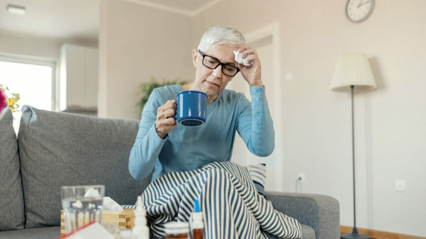 Portrait of sick, ill Woman Drinking Tea in the Living room